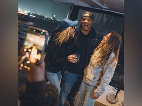 A joyful group celebrates together on a boat, capturing the moment with a phone. This lively atmosphere is perfect for parties and gatherings on the water.