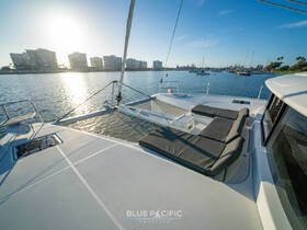A serene view of the lounge area on a catamaran, featuring comfortable seating and a beautiful waterfront backdrop, perfect for relaxing on the water.
