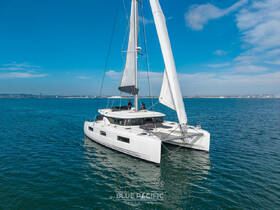 A stunning aerial view of a sleek catamaran sailing in clear blue waters, showcasing its elegant design and perfect for luxury charters or island adventures.