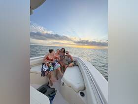 A group of friends enjoys a sunset celebration aboard a boat, sipping drinks and creating unforgettable memories on the water.