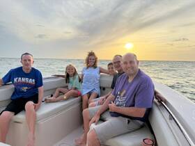 A joyful family enjoys a sunset cruise on a boat, capturing a perfect moment of togetherness and celebration on the water.