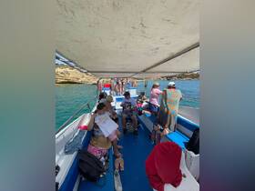 A lively group enjoys a day on the water aboard a boat, showcasing a fun beach outing with family and friends.