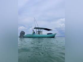A side view of a fishing boat cruising through calm waters, showcasing its sleek design and fishing gear — perfect for a day on the water.