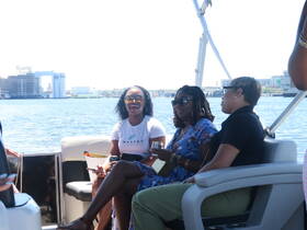 A lively group enjoys drinks and conversation aboard a boat, perfect for celebrations and social gatherings on the water.