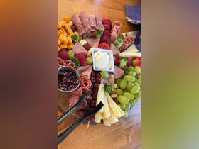 A beautifully arranged charcuterie board featuring a variety of meats, cheeses, fruits, and spreads, perfect for enjoying on a boat trip.