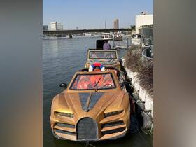 A unique golden boat docked along the river, showcasing its striking design against the urban backdrop.