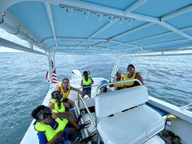 A group of excited snorkelers, including children, prepares for an underwater adventure aboard a boat, showcasing the fun of family outings on the water.