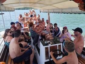 A lively group enjoys a fun-filled boat party, celebrating together on the water — perfect for family gatherings and memorable outings.
