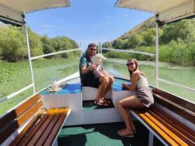A cheerful family enjoys a relaxing day on a boat, surrounded by lush greenery along the river — perfect for nature lovers and family outings.