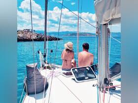 A couple enjoys a serene moment on a sailboat, taking in the stunning island scenery and crystal-clear waters — a perfect escape for sailing enthusiasts.