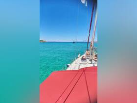 Guests relax on the deck of a sailboat, enjoying the stunning turquoise waters — an ideal setting for a day of sailing and sunbathing.