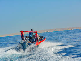 A lively group enjoys a thrilling ride on a speedboat, creating waves and excitement on the open water — perfect for adventure seekers.