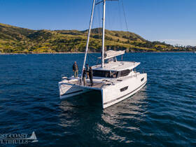 A group of friends enjoys sailing on a catamaran, showcasing the beauty of the coastline and the thrill of being on the water.