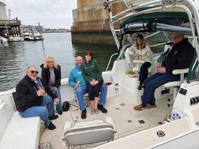 A cheerful group enjoys drinks aboard a boat, creating a lively atmosphere perfect for social gatherings and celebrations on the water.