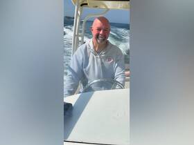 A man confidently navigates a boat, showcasing the thrill of being on the water — perfect for adventure seekers and boating enthusiasts.