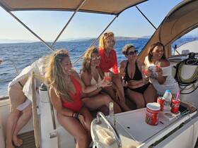 A lively group of friends enjoys cocktails on a yacht, celebrating under the sun — perfect for memorable summer outings on the water.