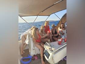 A lively group of friends enjoys cocktails aboard a yacht, celebrating together against a stunning ocean backdrop — perfect for memorable outings and gatherings on the water.