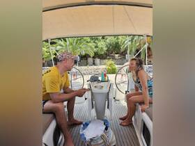 A relaxed moment inside a boat's cabin, featuring two guests enjoying conversation by the helm, perfect for showcasing the comfort of onboard living.