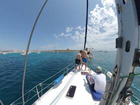 A group of friends enjoys a fun day sailing, with some preparing to jump into the clear blue waters — perfect for adventure seekers and sailing enthusiasts.