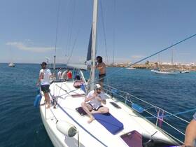 A lively group enjoys a sunny day sailing on a yacht, capturing the essence of fun and adventure on the water.