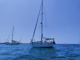 A picturesque view of a sailboat navigating through clear blue waters, showcasing the beauty of sailing adventures.