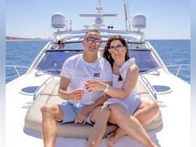 A couple enjoys a toast with cocktails on the deck of a yacht, basking in the sun — a perfect moment for romantic getaways or special celebrations on the water.