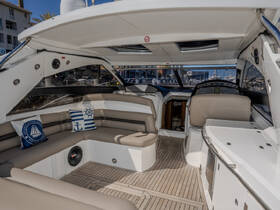 A spacious and stylish interior of a boat featuring comfortable seating and a well-equipped helm, perfect for relaxing or navigating the waters.
