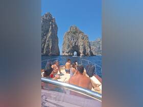 A lively group enjoys a scenic boat ride near iconic rock formations, perfect for family outings and sightseeing adventures.