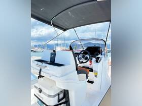 A sleek view of the helm area inside a modern boat, showcasing the console and seating, perfect for navigating the waters in style.