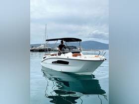 A man navigates a sleek boat through calm waters, showcasing the perfect day for a boating adventure.