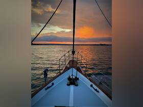A stunning view from the bow of a yacht at sunset, showcasing the tranquil waters and vibrant sky — perfect for evening cruises.