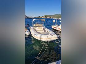 A speedboat docked at the marina, with a person preparing to board. The clear waters and scenic backdrop enhance the boating experience.