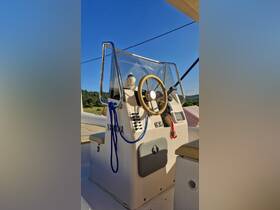 A close-up view of the helm and console of a boat, showcasing the steering wheel and control panel — perfect for those interested in boat interiors and navigation equipment.