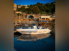A sleek speedboat named 'Blumax' docked at a picturesque marina, reflecting the serene waters and surrounding greenery.
