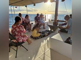 A lively group enjoys a unique experience aboard a boat at sunset, engaging in activities that create lasting memories on the water.