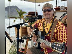 A talented musician performs live music on a boat, creating a vibrant atmosphere for guests to enjoy while sailing.