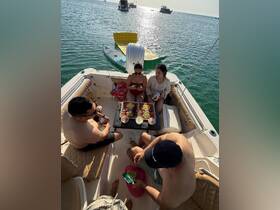 A lively group enjoys a delicious spread of food and drinks aboard a boat, perfect for a fun day on the water with friends.