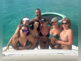 A lively group of friends poses for a fun photo on a boat, enjoying a sunny day in the water — perfect for summer celebrations and memorable outings.