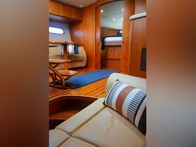 A cozy interior view of a boat cabin featuring elegant wooden finishes, comfortable seating, and a well-designed layout, perfect for relaxation while on the water.