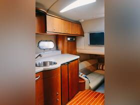 A cozy interior view of a boat's cabin featuring a well-equipped kitchenette and comfortable seating, perfect for relaxing during your nautical adventures.