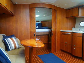 A cozy interior view of a boat cabin featuring elegant wooden finishes, comfortable seating, and a well-equipped kitchenette, perfect for relaxing during your nautical adventures.