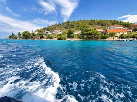 A picturesque view of a serene coastline with turquoise waters and lush greenery, perfect for showcasing the beauty of island hopping adventures.