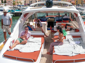 A lively group enjoys a sunny day aboard a yacht, lounging and socializing on the deck — perfect for relaxation and fun on the water.