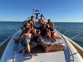 A lively group enjoys a sunny day on a yacht, lounging and celebrating with drinks — perfect for unforgettable gatherings on the water.