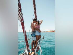 A couple shares a romantic moment on the bow of a sailboat, perfect for unforgettable sailing adventures and intimate getaways.