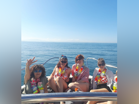A cheerful group of friends poses on a boat, enjoying a sunny day at sea — perfect for celebrations and memorable outings.