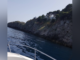 A stunning view of a rocky coastline from a boat, showcasing the serene beauty of the ocean and the lush greenery above — perfect for scenic cruises.