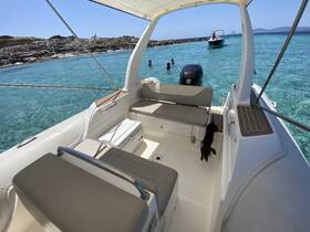 A cozy interior view of a boat with comfortable seating, showcasing a relaxed atmosphere perfect for enjoying the clear waters and nearby activities.