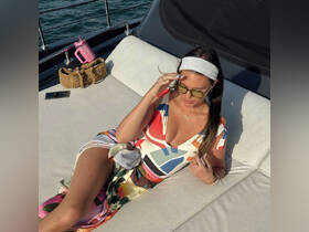 A woman relaxes on a luxurious boat deck, enjoying the sun and the serene waters — a perfect moment for leisure and relaxation on the water.