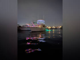 A beautifully decorated yacht illuminated with colorful lights, reflecting on the calm waters at night — perfect for festive evening cruises.